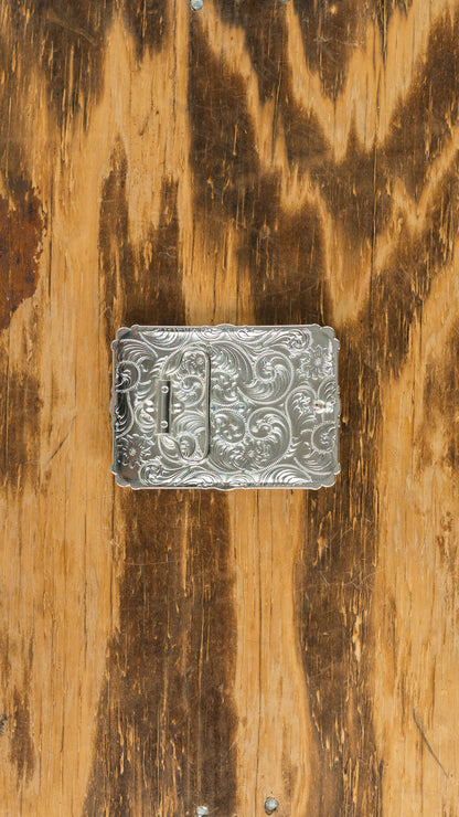 Silver rectangle with coper background under gold San Judas shape with red color stones in each corner belt buckle