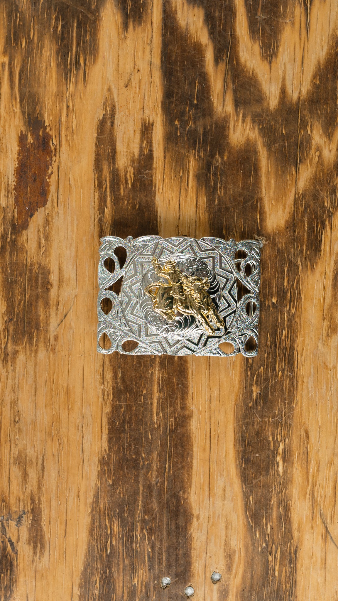 Silver rectangle shape buckle with gold cowboy on horse in the center belt buckle